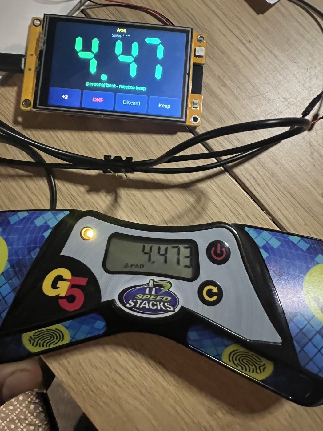 A SolveBlock prototype screen reading 4.47 next to a Speed Stacks G5 timer reading 4.473.